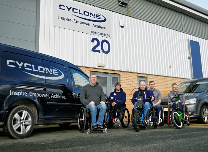 Cyclone team at front of Widnes mobility showroom and offices showcasing a variety of wheelchairs and Batec's
